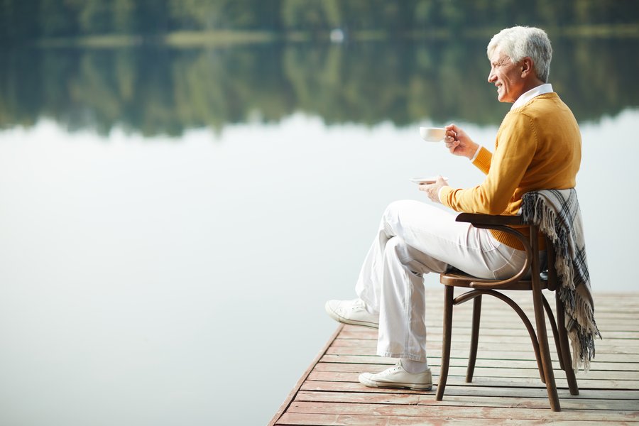 Business owner enjoying a quiet morning coffee by the lake after a merger